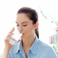 Women in blue shirt drinking water